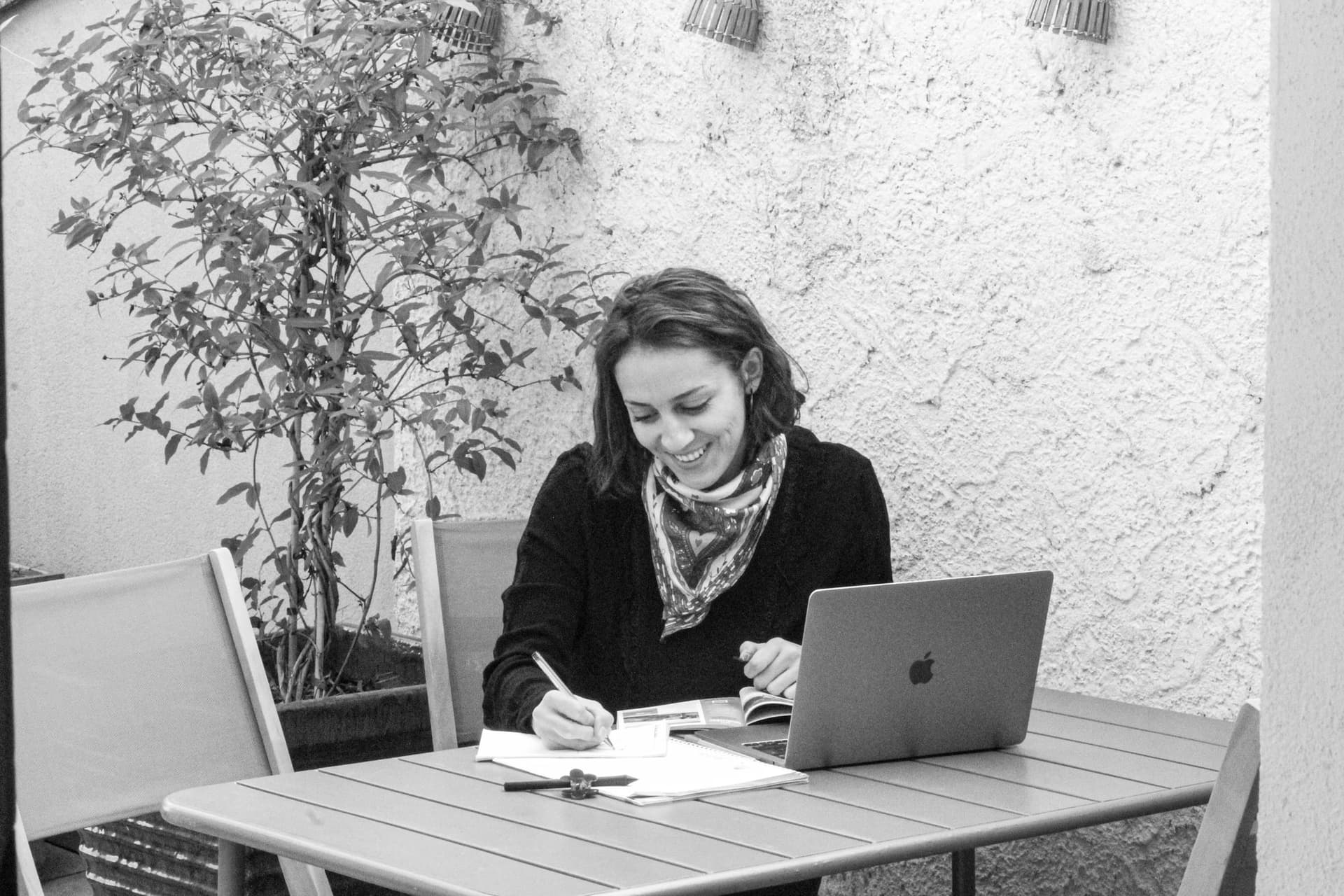 Mélanie Galichon souriante, carnet et stylo en main, à son bureau.
